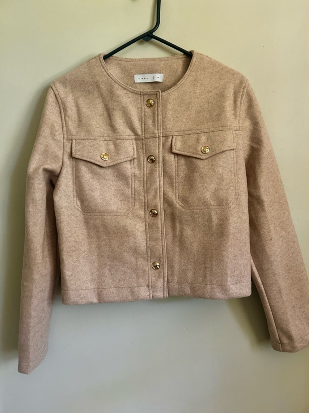 Lyra & Co. Beige Cropped Jacket. Snap front with gold accents.